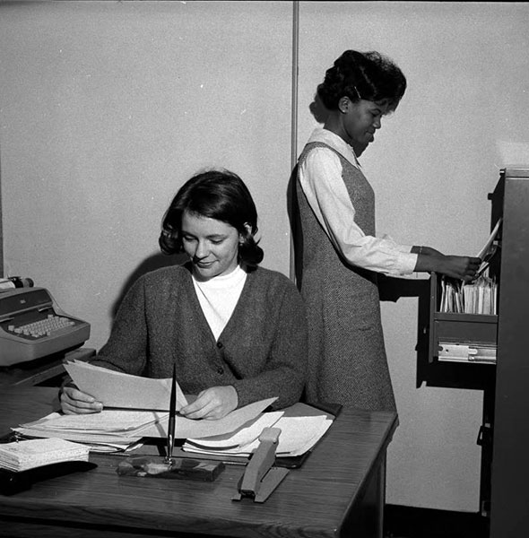 Students Sharon McCullough reads while Barbara Hatcher files