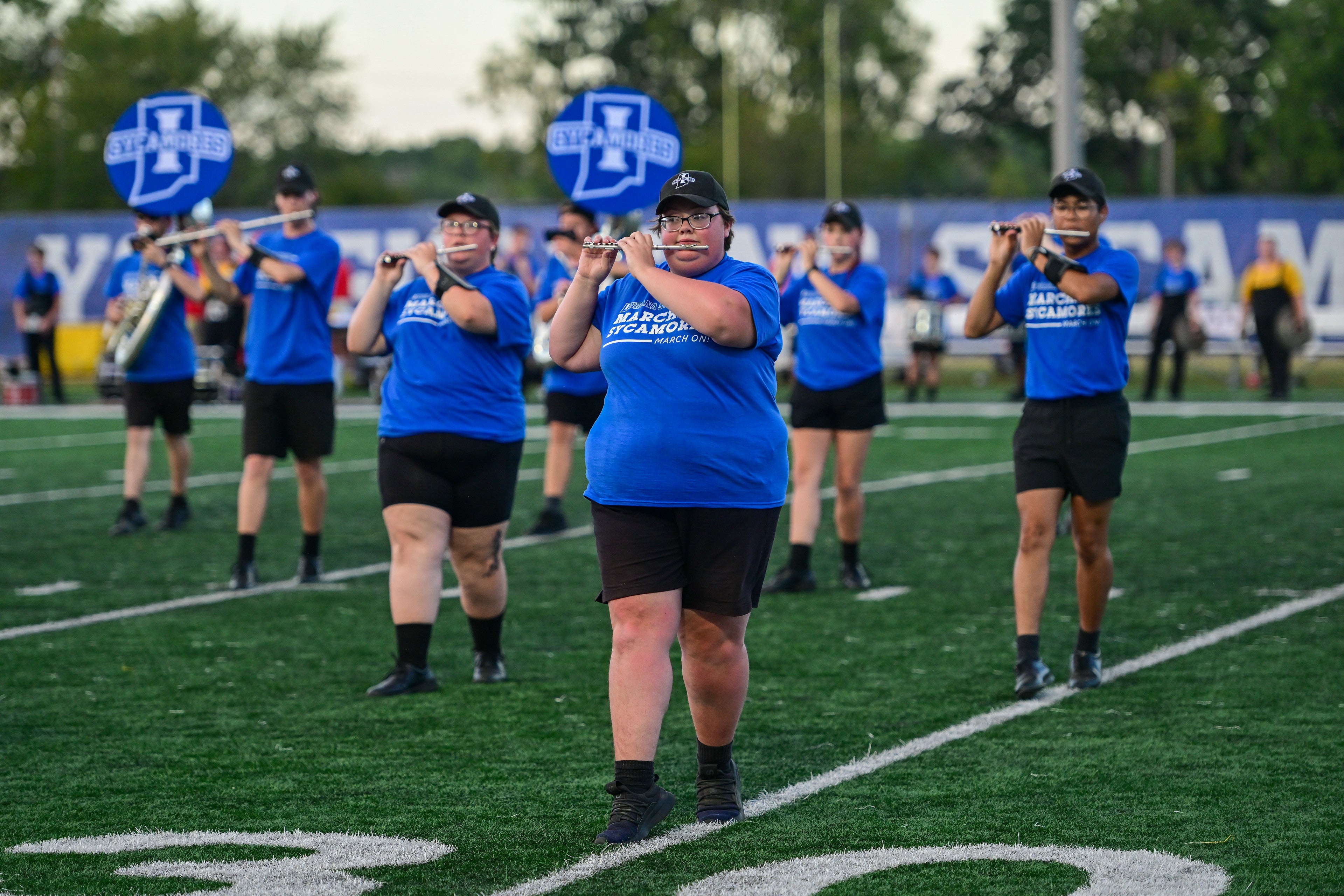 Sycamore members in blue uniforms playing on a football field